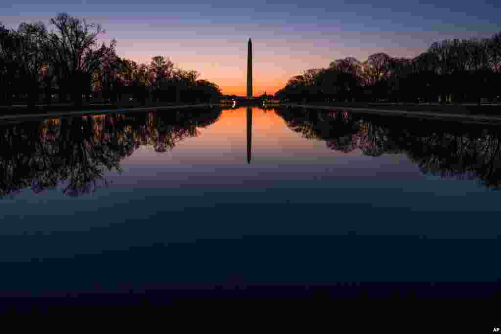 Reflexo do monumento a George Washington ao nascer do Sol na capital americana.