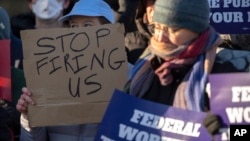 Demonstrators rally in support of federal workers outside of the Department of Health and Human Services in Washington, Feb. 14, 2025.