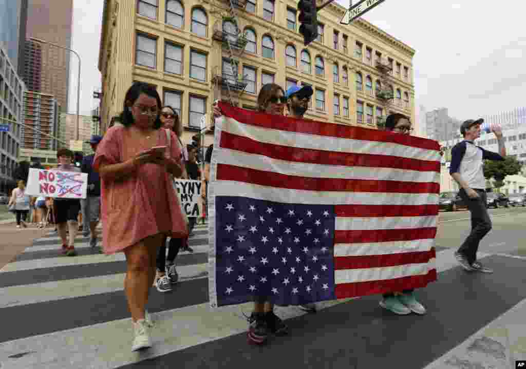 Manifestantes exibem uma bandeira virada de pernas para o ar - um sinal de desagrado - enquanto marcham na baixa de Los Angeles em protesto contra Presidente-eleito Donald Trump, Nov. 12, 2016.