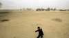 A child walks across a sand dune in Gansu province, China, where desertification threatens for force farmers from their land.