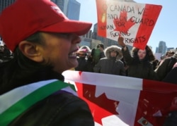 Seorang penentang (kiri) dari mosi pemerintah federal anti-Islamofobia M-103 berdebat dengan seorang pengunjuk rasa tandingan selama rapat umum di luar Balai Kota di Toronto, Ontario, Kanada 4 Maret 2017. (Foto: REUTERS/Chris Helgren)