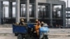 FILE - Workers ride in a vehicle at the construction site of the Dangote oil refinery in Ibeju Lekki district, on the outskirts of Lagos, Nigeria, Aug. 7, 2019. 