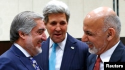 With U.S. Secretary of State John Kerry (C) watching, Afghanistan President Mohammad Ashraf Ghani (R) talks with Afghan Chief Executive Abdullah Abdullah at a NATO foreign ministers meeting in Brussels, Dec. 2, 2014.