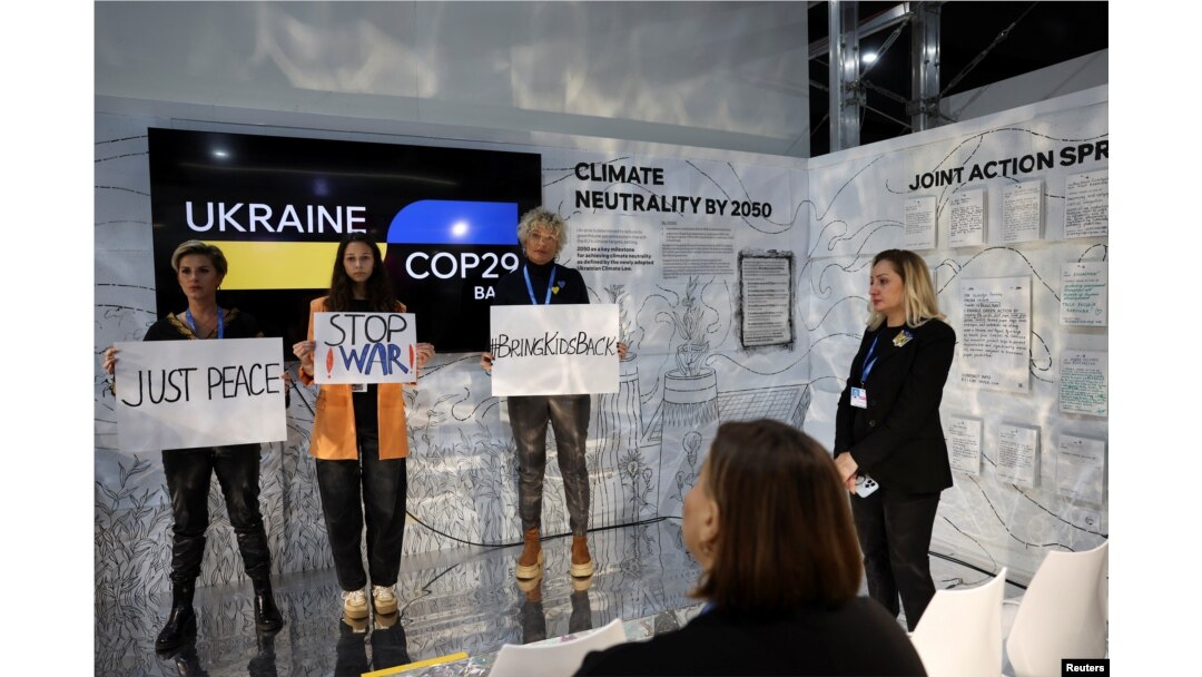 Para perempuan memegang plakat saat menghadiri protes pro-Ukraina, pada konferensi perubahan iklim Perserikatan Bangsa-Bangsa COP29, di Baku, Azerbaijan 19 November 2024. (Murad Sezer/REUTERS)