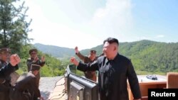 Pemimpin Korea Utara Kim Jong Un bereaksi saat uji coba rudal balistik antar benua Hwasong-14.