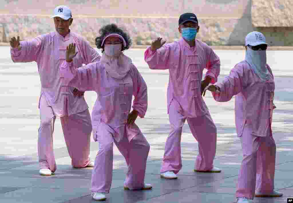 Taiji practitioners, some wearing masks, go through their routine in Beijing.