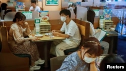 Warga makan di restoran di kawasan Shibuya, di tengah lonjakan kasus COVID-19 di Tokyo, Jepang, Kamis (29/7). 