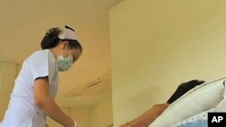 A nurse preps an HIV-infected patient in Bangkok, Thailand, for a round of anti-retroviral drugs, Nov 2010