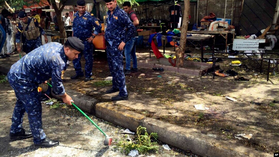 Iraqi security forces clean the scene of a bomb in Kadhimiyah district, Baghdad, Iraq, July 24, 2016. 