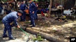 Iraqi security forces clean the scene of a bomb in Kadhimiyah district, Baghdad, Iraq, July 24, 2016. 