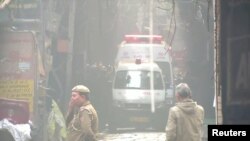 8일 인도 뉴델리 재래시장 내 공장 화재 현장에 구조대가 출동한 가운데 경찰이 주변을 살피고 있다. 