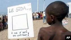 A Morrocan child looks at a sign on a Casablanca beach where an outreach campaign against AIDS is held, organized by the Morrocan Youth Association Against AIDS (AMJCS) (2002 file photo)