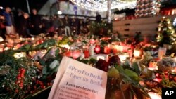 Warga berkumpul di depan lilin-lilin dekat pasar Natal di gereja memorial Kaiser Wilhelm di Berlin, Jerman (21/12), dua hari setelah serangan truk maut. (AP/Michael Sohn)