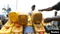 FILE - A water vendor offloads jerry cans of water to his hand-cart in the outskirts of Kenya's capital Nairobi, July 25, 2009. 