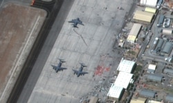 A view of people waiting in line to board the C-17 Globemaster III aircraft at the Hamid Karzai International Airport, in Kabul, Afghanistan August 27, 2021. Satellite image 2021 Maxar Technologies/Handout via REUTERS