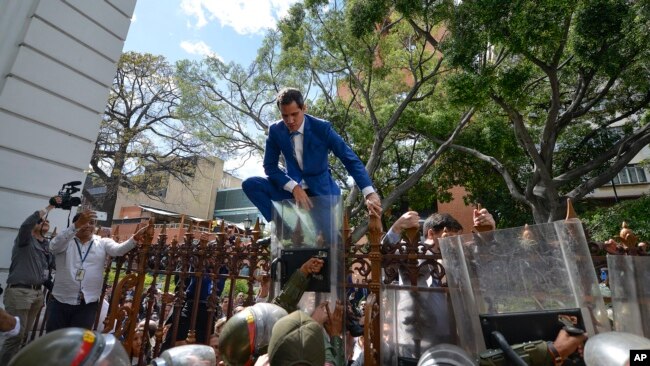 委内瑞拉议长瓜伊多在被安全部队阻拦后试图翻墙进入议会。(2020年1月5日)