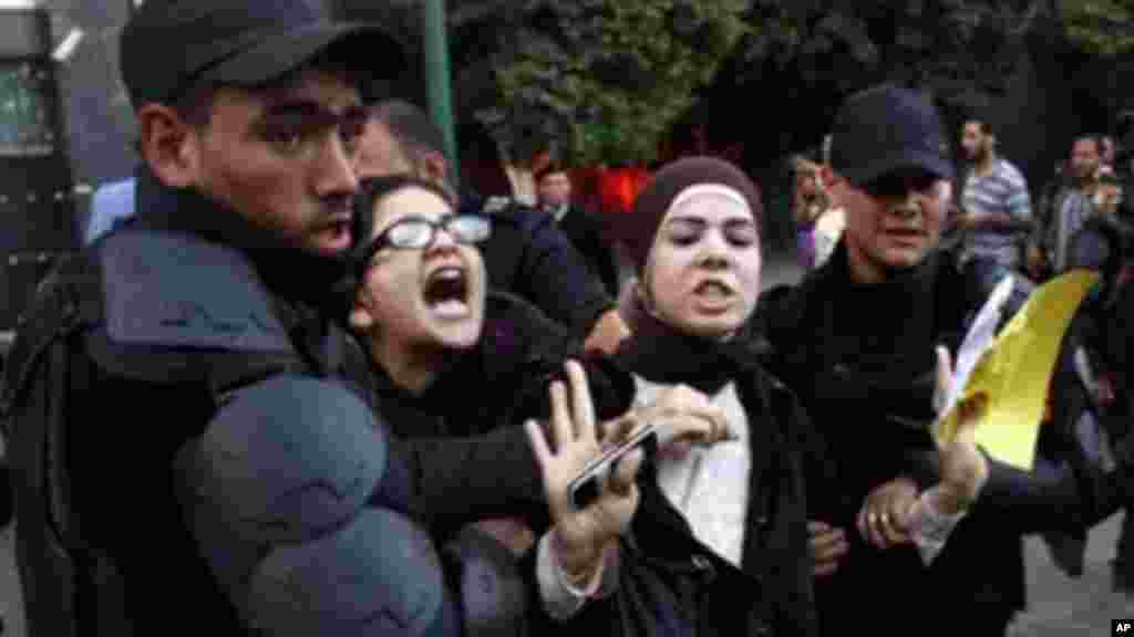 Egyptian police detain two female protesters in Cairo, November 26, 2013.