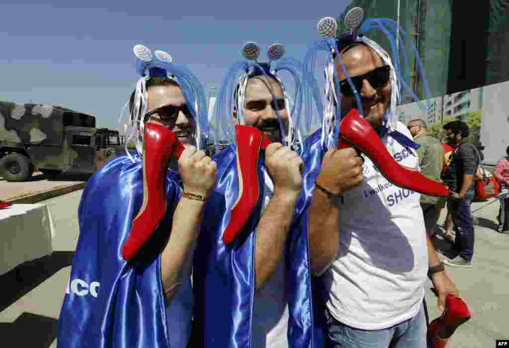 Lebanese men pose with their shoes before taking part in a mile-long walk in women's high heels during the "Walk a Mile in her Shoes" event to call to end violence against women in Dbayeh, north of the Lebanese capital Beirut.