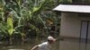 A man pulls a giant jar in flood waters on a street in Kandal province September 30, 2011. Some 141 people have died in Cambodia since Aug. 13 in the worst flooding along the Mekong River in 11 years after heavy rain swamped homes, washed away bridges and