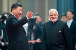 中国领导人习近平在山东青岛欢迎印度总理莫迪出席上合组织峰会。（2018年6月10日）