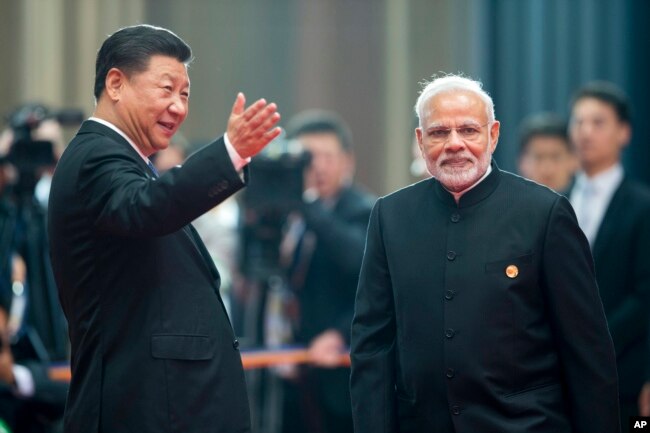 中国领导人习近平在山东青岛欢迎印度总理莫迪出席上合组织峰会。（2018年6月10日）