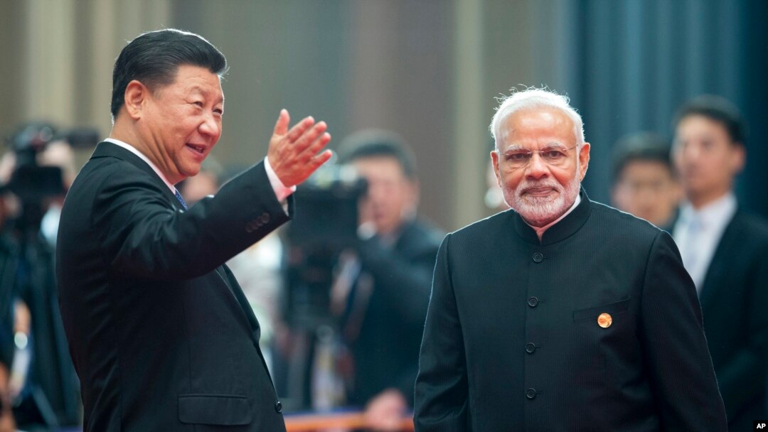 FILE - Chinese President Xi Jinping, left, welcomes Indian Prime Minister Narendra Modi for a meeting at a Shanghai Cooperation Organization summit in Qingdao in eastern China's Shandong province, June 10, 2018. 