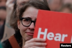 A protester holds a sign against the confirmation of U.S. Supreme Court nominee Brett Kavanaugh outside the U.S. Capitol ahead of the scheduled Senate confirmation vote in Washington, Oct. 6, 2018.