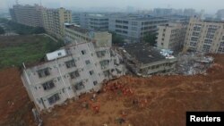 Tim pemadam kebakaran tengah berupaya melakukan pencarian korban di antara reruntuhan gedung yang terkena longsor di Shenzhen, provinsi Guangdong, 21 Desember 2015 - (REUTERS/Stringer)