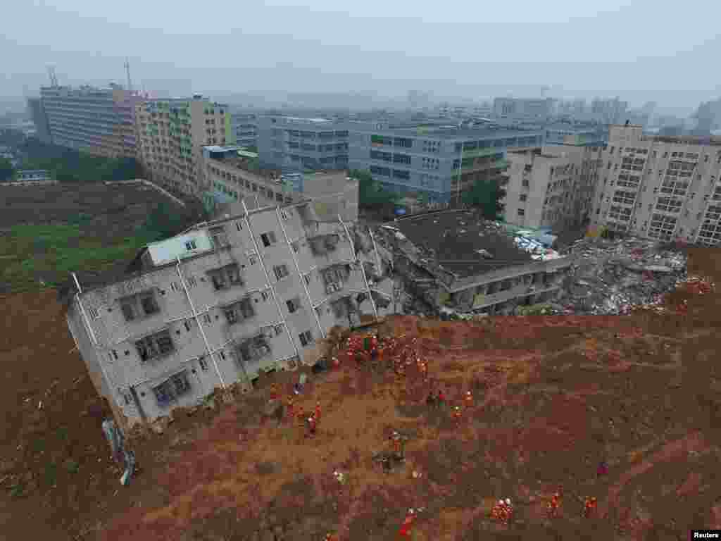 Petugas pemadam kebakaran mencari korban longsor yang selamat di antara reruntuhan gedung di Shenzhen, provinsi Guangdong, China, 21 Desember 2015.