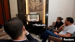 Reporters watch a live feed of Libyan members of parliament meeting to decide on the new prime minister at the parliament in Tripoli, May 4, 2014. 