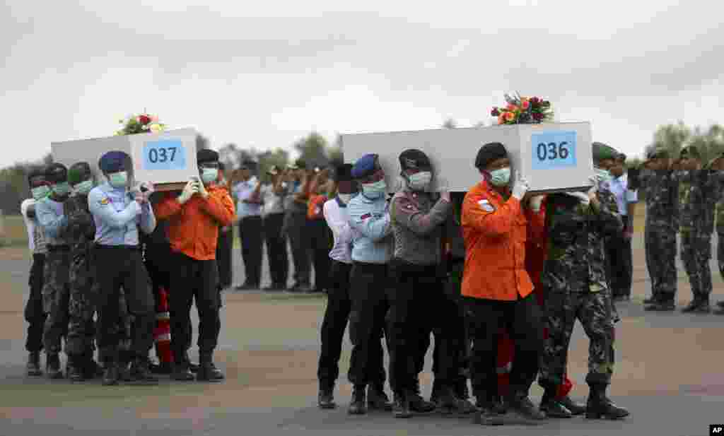 Members of the National Search And Rescue Agency and Indonesian soldiers carry the coffins of the victims who were aboard AirAsia Flight 8501 at the airport in Pangkalan Bun, Indonesia, Jan. 5 2015.