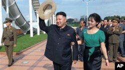 北韓朝中社7月26日發佈的圖片顯示﹐北韓領導人金正恩和他的夫人李雪主7月25日出席了首都平壤綾羅人民遊園地竣工儀式向群眾揮手。