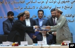 FILE - Amin Karim, representative of Gulbuddin Hekmatyar, right, and Attaurahman Saleem, head of delegation of peace talks, left, exchange documents after signing a peace deal in Kabul, Afghanistan, Thursday, Sept. 22, 2016.