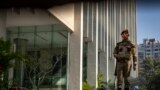 FILE - An armed security person stands guard at the gate of a building housing BBC office in New Delhi, India, on Feb. 15, 2023. Indian police raided the offices of a news website and homes of journalists, in what critics described as an attack on an independent news outlet.