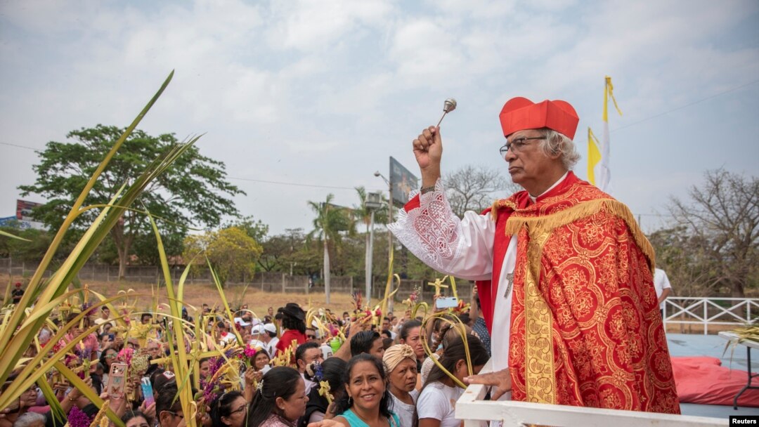 El Cardenal Leopoldo Brenes bendice mientras la gente levanta sus palmas para recibir bendiciones durante una misa del Domingo de Ramos en Managua, Nicaragua, el 24 de marzo de 2024. 