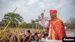 El Cardenal Leopoldo Brenes bendice mientras la gente levanta sus palmas para recibir bendiciones durante una misa del Domingo de Ramos en Managua, Nicaragua, el 24 de marzo de 2024. 