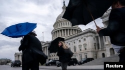 Un cierre del gobierno de EEUU continúa como una amenaza al enfrascarse discusiones entre republicanos y demócratas sobre el nivel de gasto. Un grupo de personas son captadas en las afueras del Capitolio en Washington capeando un fuerte viendo y lluvia el 27 de febrero de 2024.