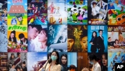 Visitors walk past a display of posters for Chinese movie and television productions at the China International Fair for Trade in Services in Beijing, Sept. 3, 2021. 