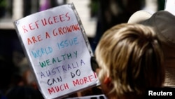 FILE - Protesters hold placards at a "Stand up for Refugees" rally held in central Sydney, Oct. 11, 2014.