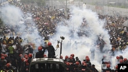 Malaysian riot police officers fire tear gas at activists from Coalition for Clean and Fair Elections (Bersih) during a rally in Kuala Lumpur, Malaysia, July 9, 2011