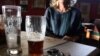 A woman waits for a designated driver in a bar in Johannesburg after a night out with friends, Sept. 17, 2015. (VOA / D. Taylor)