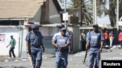 FILE - Police patrol the streets after overnight unrest and looting in Alexandra township, Johannesburg, South Africa, Sept. 3, 2019.
