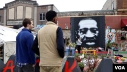 Minnesota state Sen. Omar Fateh, in vest, and legislative aide Dawson Kimyon visit the George Floyd memorial site in Minneapolis, Minn. (Betty Ayoub/VOA)