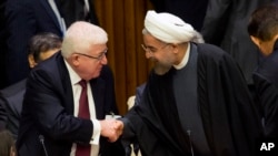 FILE - Iraq's President Fuad Masum, left, is greeted by Iranian President Hassan Rouhani as he arrives at the Climate Summit 2014 at U.N. headquarters, Sept. 23, 2014. 