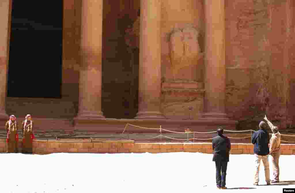 U.S. President Barack Obama (C) stops to look at the Treasury while he receives a tour of the ancient historic and archaeological site of Petra, Jordan.