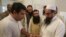 An election officer marks a thumb of Hafiz Saeed, right, head of the Pakistani religious party Jamaat-ud-Dawa, at polling station in Lahore, Pakistan, July 25, 2018. 