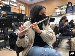 A student plays the flute while wearing a protective face mask during a music class at the Sinaloa Middle School in Novato, Calif., Tuesday, March 2, 2021. (AP Photo/Haven Daily)