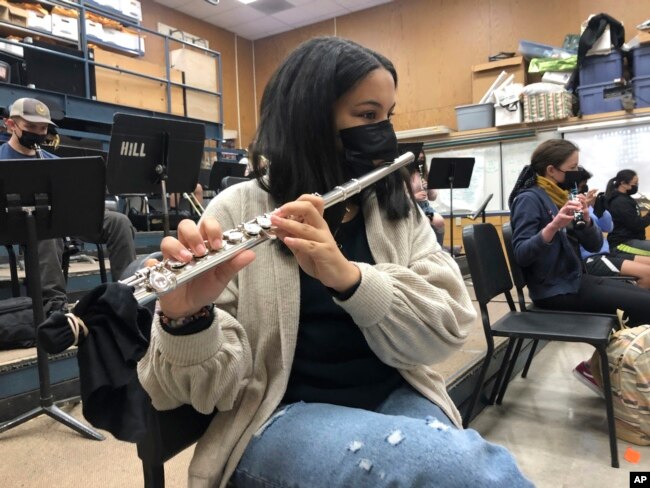 A student plays the flute while wearing a protective face mask during a music class at the Sinaloa Middle School in Novato, Calif., Tuesday, March 2, 2021. (AP Photo/Haven Daily)