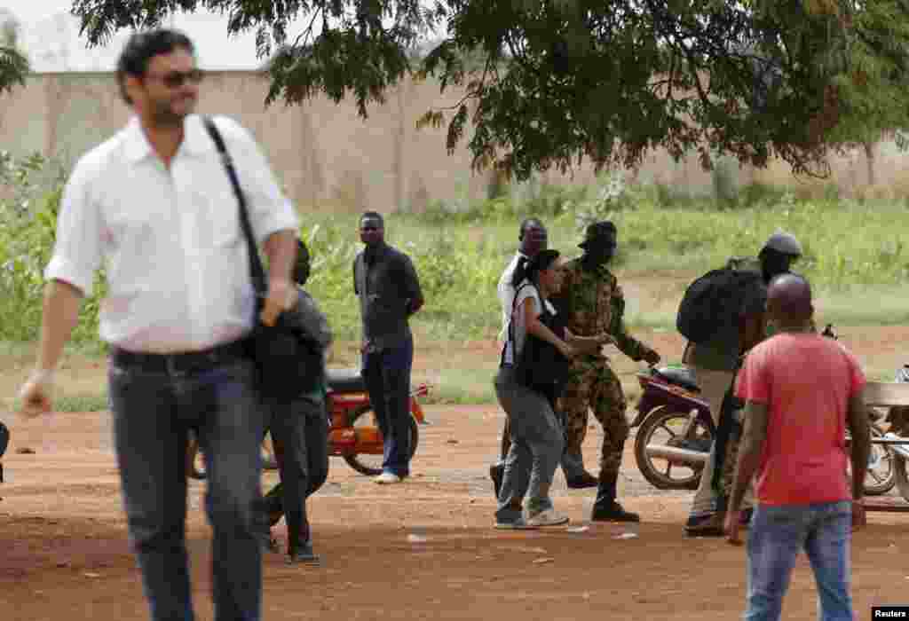 Presidential guard soldiers charge protesters and journalists at Laico hotel in Ouagadougou, Burkina Faso, September 20, 2015. Pro-coup demonstrators in Burkina Faso on Sunday invaded the hotel due to host talks aimed at hammering out the details of a dea