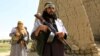 FILE - Members of the Taliban walk in Ghanikhel district of Nangarhar province, Afghanistan, June 16, 2018.